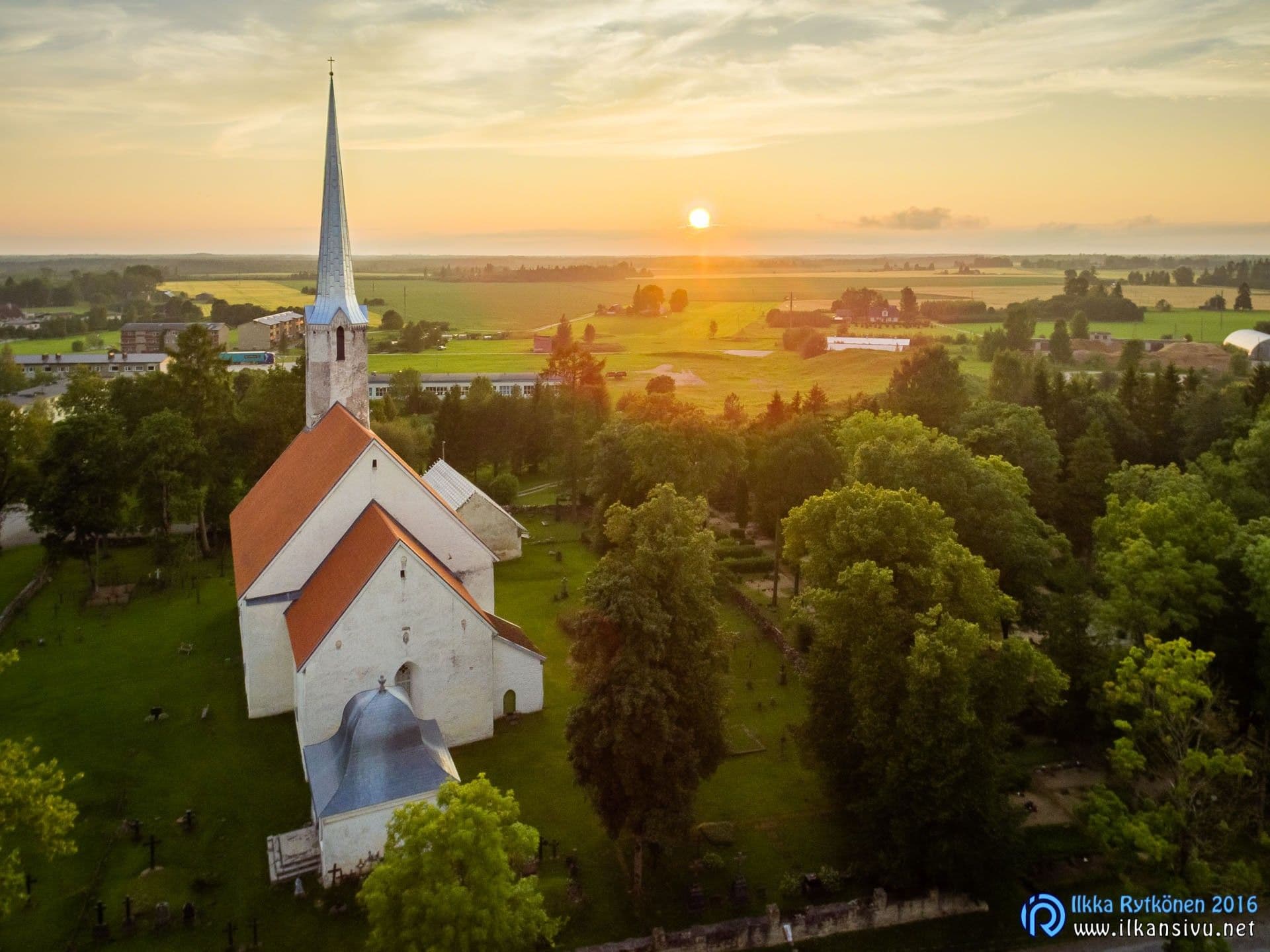 Aerial view of a white church at sunset