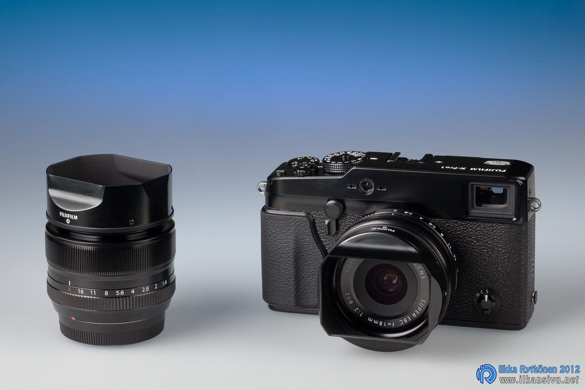 Fujifilm X-Pro1 -kamera ja erillinen objektiivi siniharmaalla liukuväritaustalla