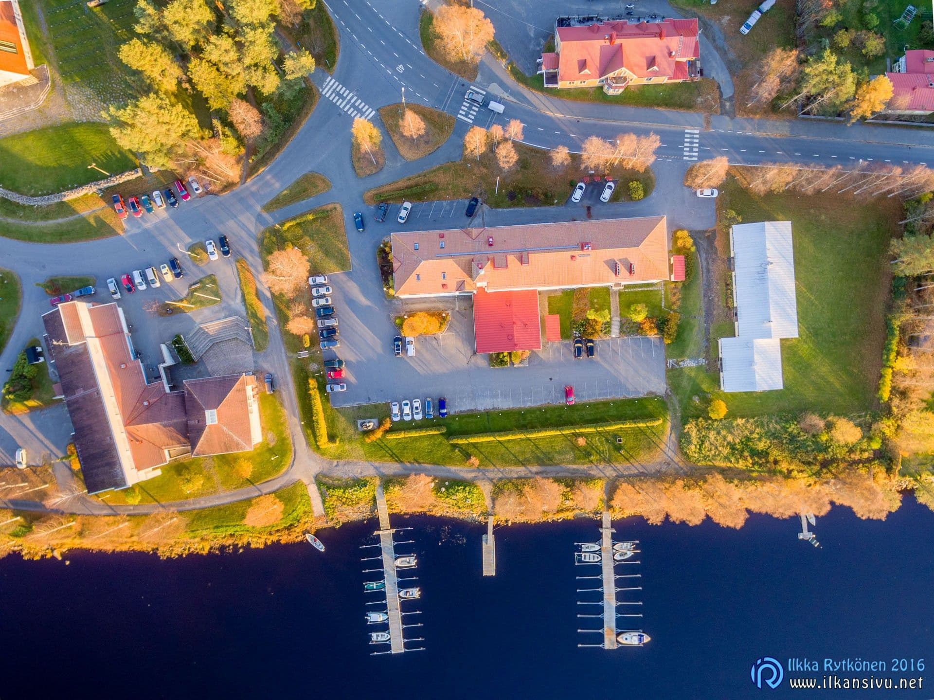 Waterfront buildings, autumn trees and jetties seen directly from above